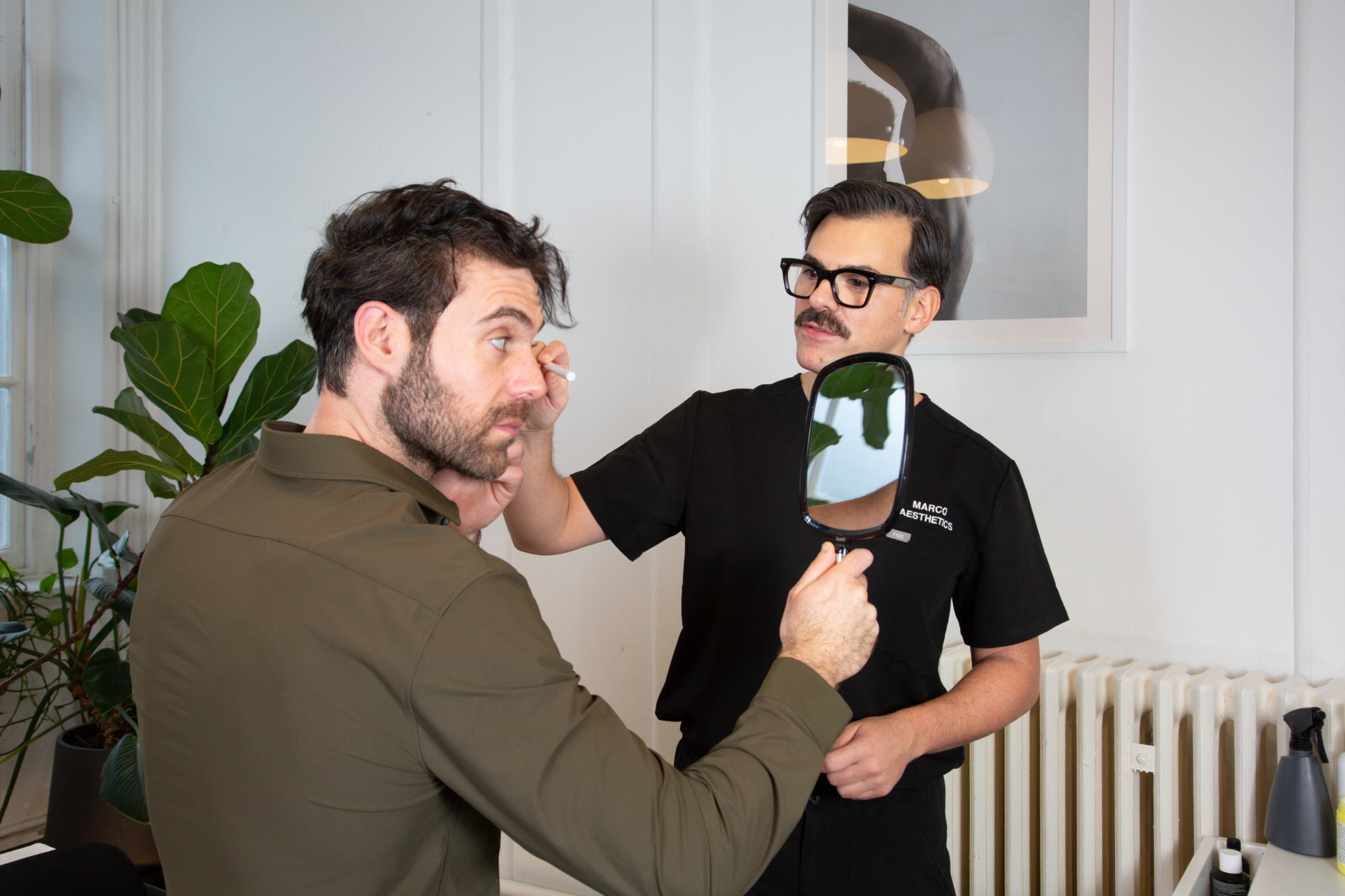 Marco discusses jaw filler treatment with a male client
