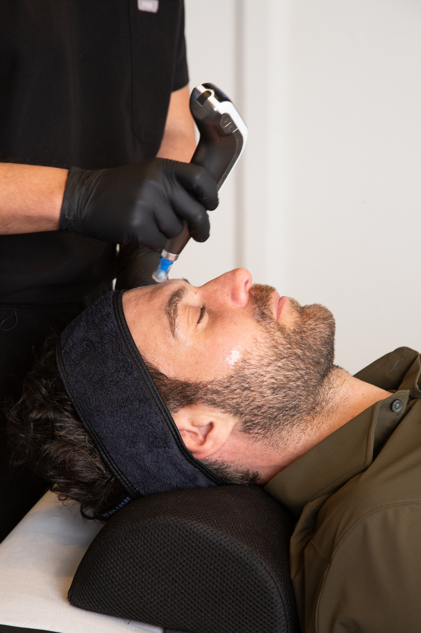 Marco administers exosomes treatment to a male client