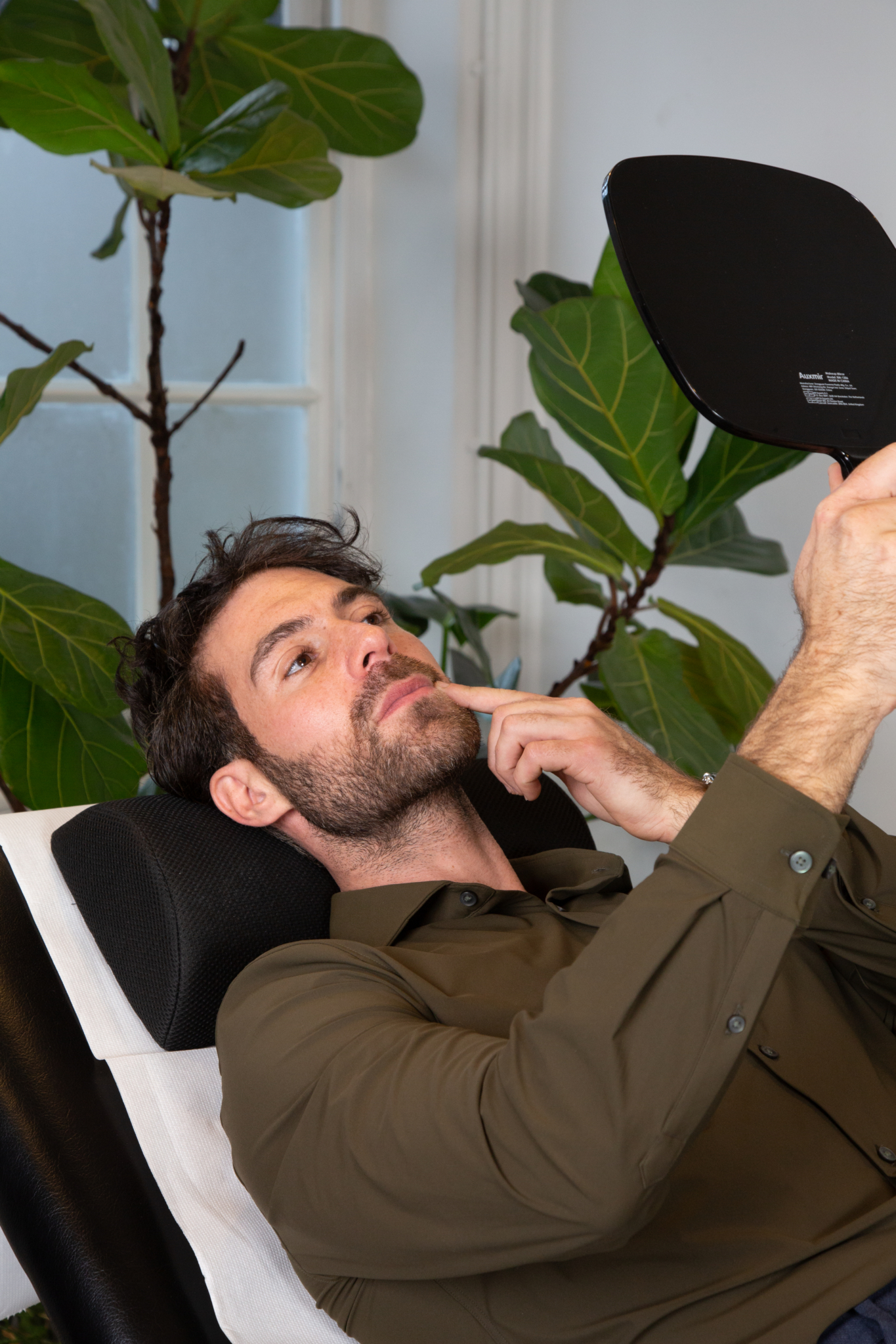 A client of Marco's assesses the results of his nasolabial folds filler in a mirror