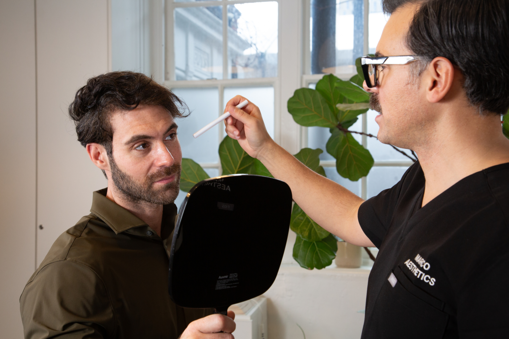 Marco prepares a client for nasolabial folds filler treatment in his Shoreditch, London studio