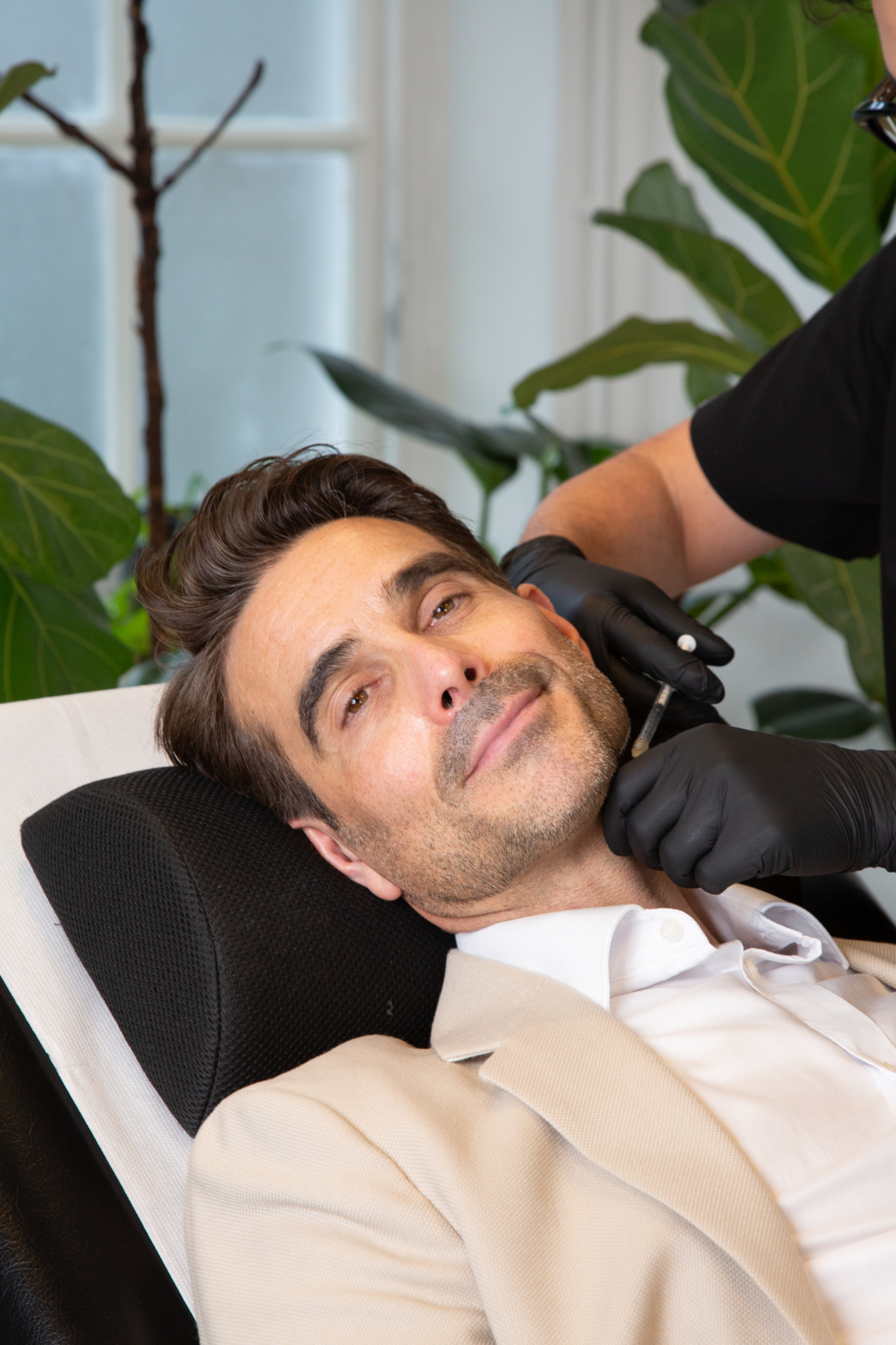Marco administers treatment for a Nefertiti lift on a male client