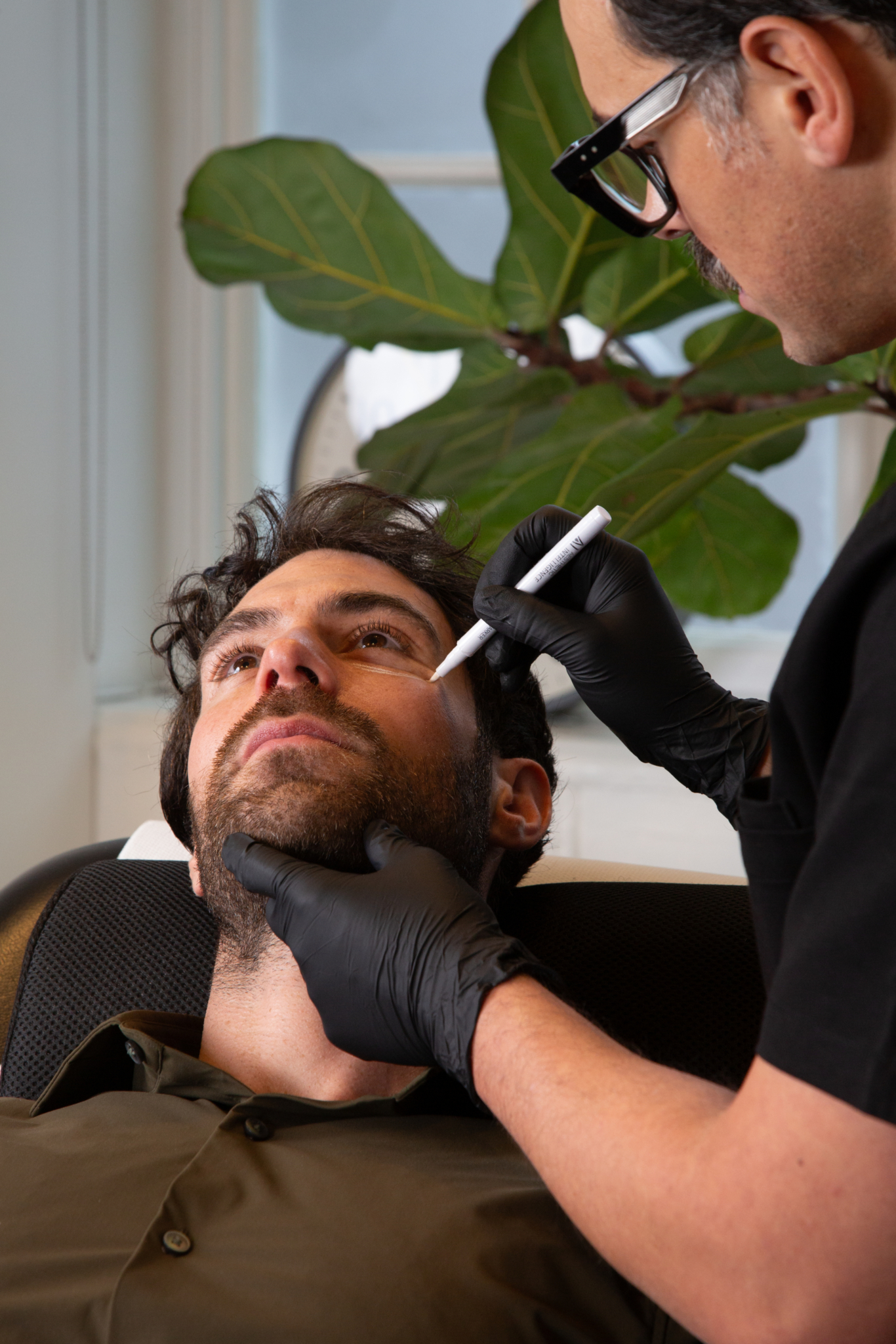 Marco prepares a male client in his Shoreditch, London studio for under eye treatment